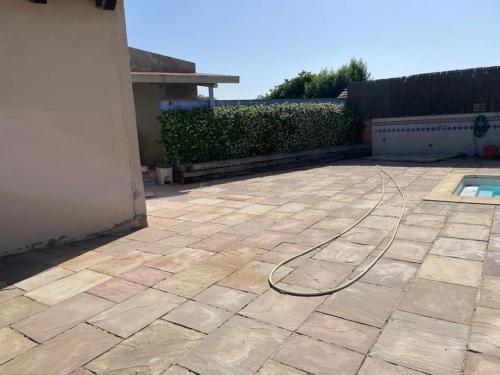 a hose on a patio next to a pool at Ca l’Avi Forner in Llobera