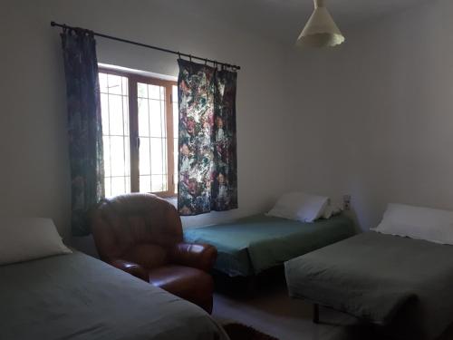 a room with two beds and a chair and a window at Camping Kapxhiu in Peshkopi