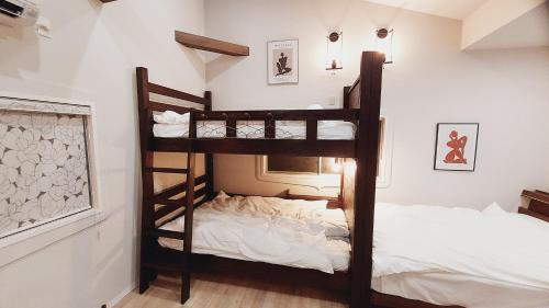 two bunk beds in a room with a bed at 日向サーフキャンプ210 in Hyuga