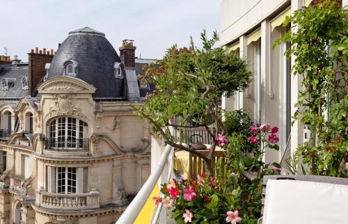 un bâtiment avec des fleurs devant lui dans l'établissement GuestReady - Stunning Apt near Champs Elysées, à Paris