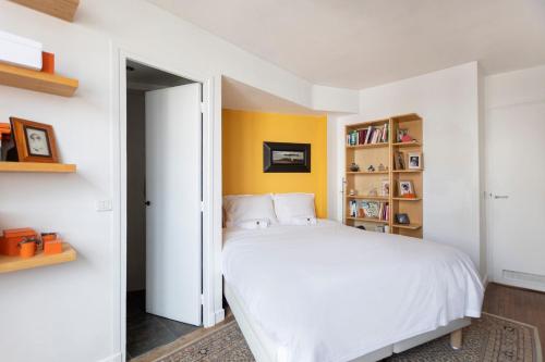 - une chambre avec un lit blanc et une étagère dans l'établissement GuestReady - Stunning Apt near Champs Elysées, à Paris