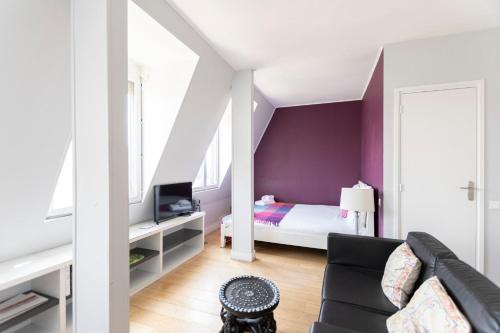 - un salon avec un canapé et une chambre dans l'établissement GuestReady -Cozy Apartment with Eiffel Tower view, à Paris
