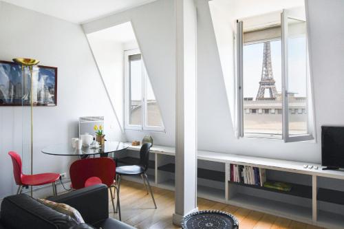 - un salon avec une table et la tour Eiffel dans l'établissement GuestReady -Cozy Apartment with Eiffel Tower view, à Paris