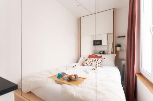 une chambre avec un lit blanc et un miroir dans l'établissement Super central mini studio - 2 pax, murphy bed, à Paris