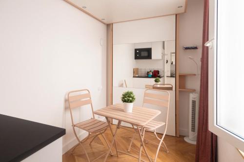 Ce petit appartement comprend une petite table et des chaises. dans l'établissement Super central mini studio - 2 pax, murphy bed, à Paris