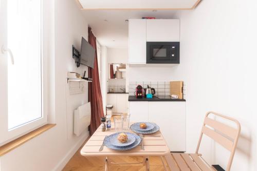 - une petite cuisine avec une table et 2 assiettes dans l'établissement Super central mini studio - 2 pax, murphy bed, à Paris