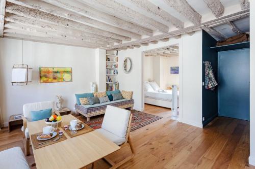 un salon avec une table, des chaises et un canapé dans l'établissement GuestReady - Apt in the heart of Latin Quarter, à Paris