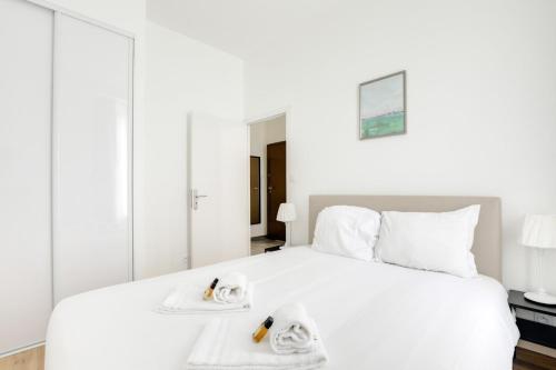 une chambre avec un lit blanc avec des serviettes dessus dans l'établissement GuestReady - 1chambre, 5min Gare Part Dieu, à Lyon