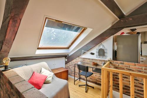 un salon avec un canapé, une table et une fenêtre dans l'établissement Rustic Bohemian Duplex in Meudon, à Meudon