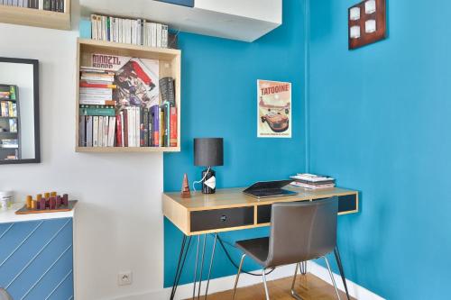 - un bureau dans une chambre dotée d'un mur bleu dans l'établissement GuestReady - Modern and Cosy apt in the 15th, à Paris