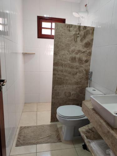 a bathroom with a toilet and a sink at Pousada Chácara Pau - Brasil in Lagoa Sêca