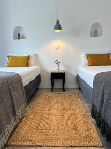 two beds in a room with a side table at Casa Postigo no Campo in Campinho