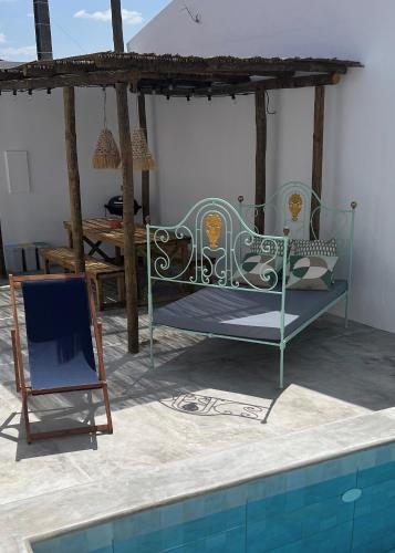 a bed and a chair next to a swimming pool at Casa Postigo no Campo in Campinho