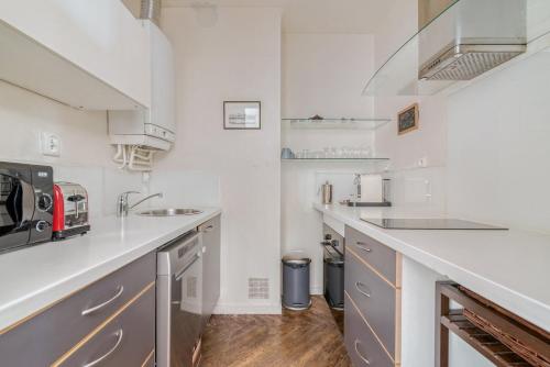 Una cocina blanca con fregadero y encimera. en GuestReady - Superbe T3 en hyper-centre - belles vues, en Fourvière