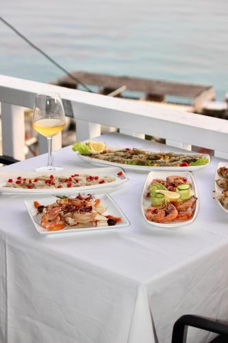 a table with plates of food and a glass of wine at Qeparo Napolon Complex in Qeparo