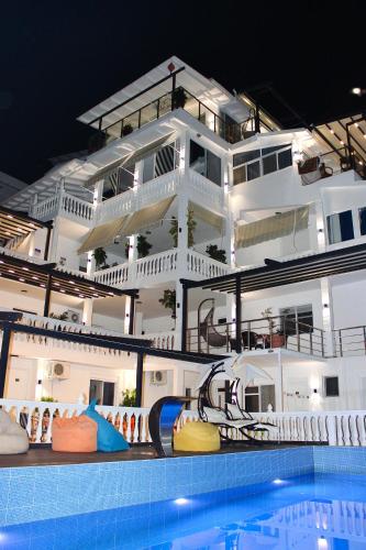 a large white building with a pool in front of it at Qeparo Napolon Complex in Qeparo
