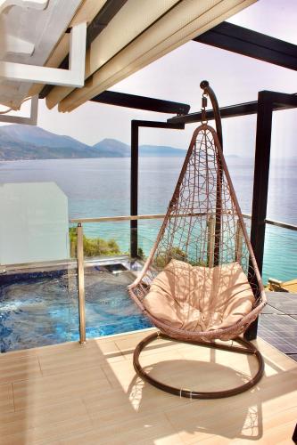 a swing on a porch with a view of the water at Qeparo Napolon Complex in Qeparo