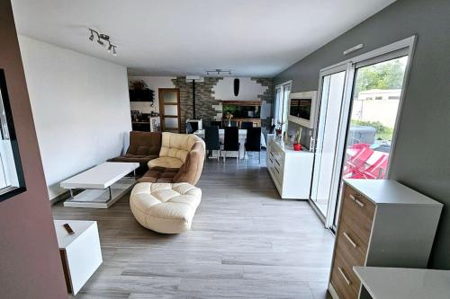 un salon avec des canapés et un salon avec une cuisine dans l'établissement Maison calme entre terre et mer, à Saint-Romain-de-Benet