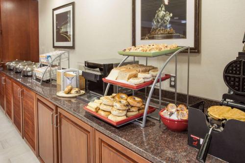 a counter with several trays of bread and pastries at Wingate by Wyndham - Dulles International in Chantilly