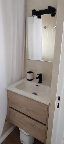 a bathroom with a sink and a mirror at Apartamentos Can Salas in Cala Figuera