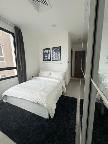 Un dormitorio blanco con una cama grande y una ventana. en 48 residence, en Kuwait