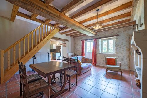 Il comprend une cuisine et un salon avec une table et un escalier. dans l'établissement Longère typique à la campagne, à Continvoir