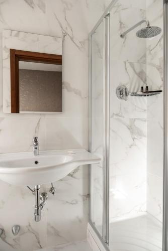 a white bathroom with a sink and a shower at Hotel Re Enzo in Bologna