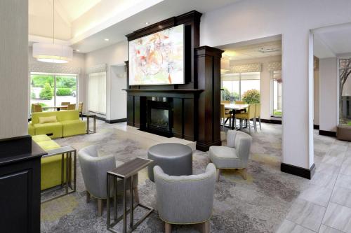 a living room with a tv and a fireplace at Hilton Garden Inn Greensboro in Greensboro