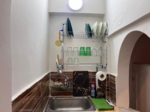 uma cozinha com um lavatório e uma prateleira por cima em Entire Modern studioin zamalek em Cairo