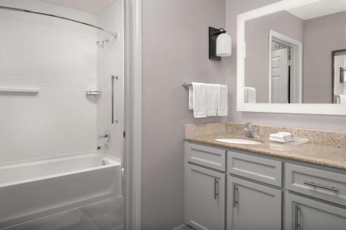 a bathroom with a sink and a tub and a mirror at Homewood Suites by Hilton San Antonio Riverwalk/Downtown in San Antonio