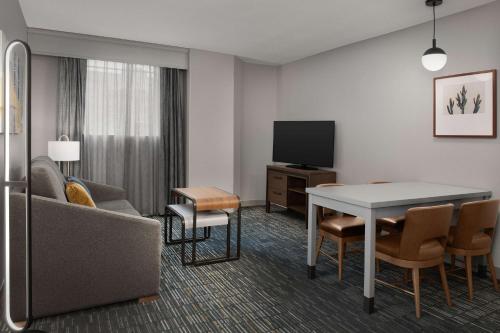 a living room with a couch a table and a television at Homewood Suites by Hilton San Antonio Riverwalk/Downtown in San Antonio