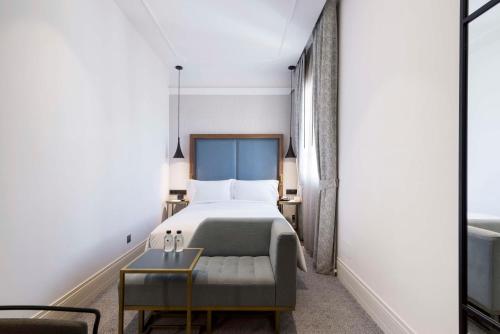 a hotel room with a bed and a chair at DoubleTree by Hilton Madrid-Prado in Madrid