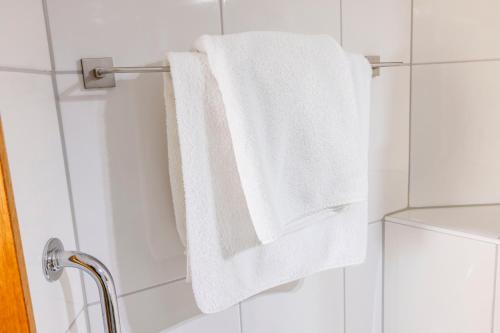 a white towel hanging on a towel rack in a bathroom at Hotel Het Landhuis in Oldenzaal
