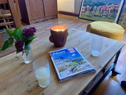 a table with a book and glasses and a candle at Les granges d'Arvieux vue sur le Queyras in Arvieux