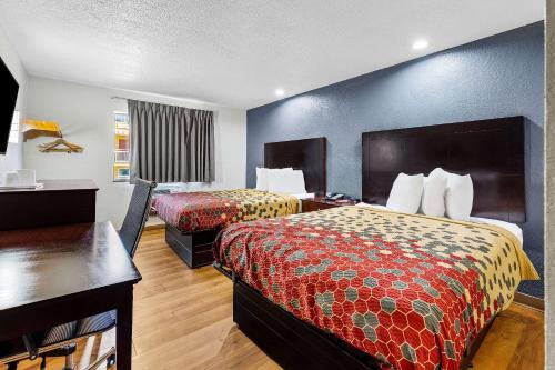 a hotel room with two beds and a desk at Econo Lodge Akron Copley Northwest in Montrose