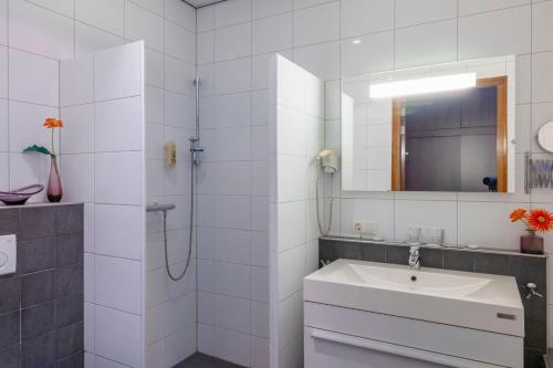 a white bathroom with a sink and a shower at Hotel Het Landhuis in Oldenzaal