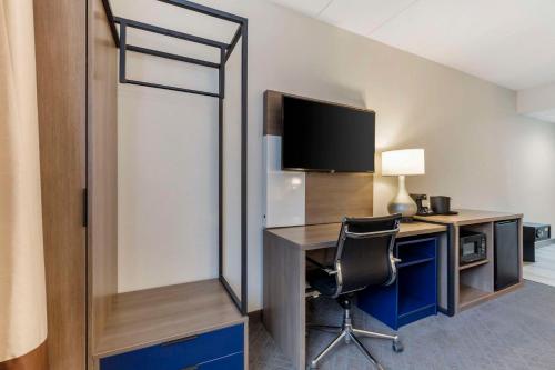 a room with a desk with a television and a chair at Comfort Inn Herndon-Reston in Herndon