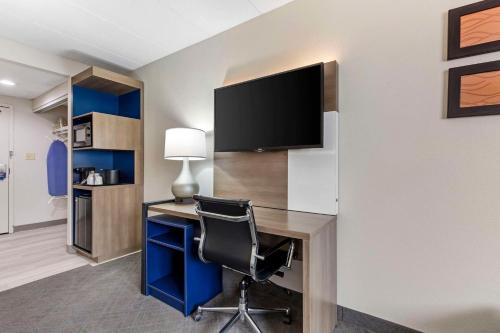 a room with a desk with a television and a chair at Comfort Inn Herndon-Reston in Herndon