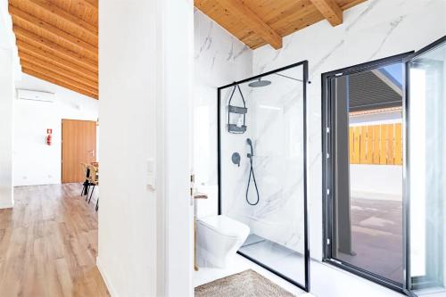 a bathroom with a toilet and a glass shower at Esteva CountryHouse in Rogil
