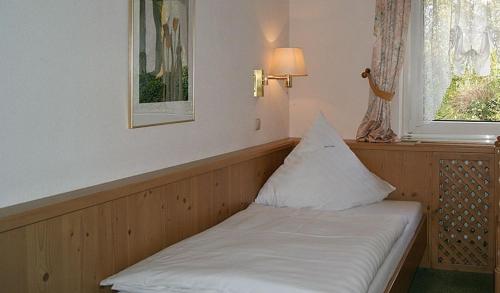 a bed in a room with a pillow on it at Hotel Keller in Kreuztal