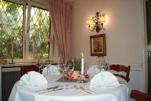 uma sala de jantar com uma mesa com copos de vinho em Hotel Keller em Kreuztal