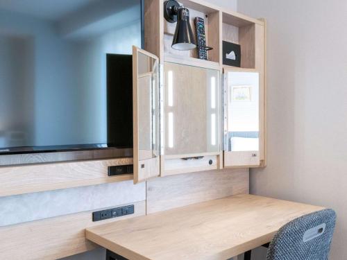 a kitchen with wooden cabinets and a tv at Comfort Hotel Nagoya Shinkansenguchi in Nagoya