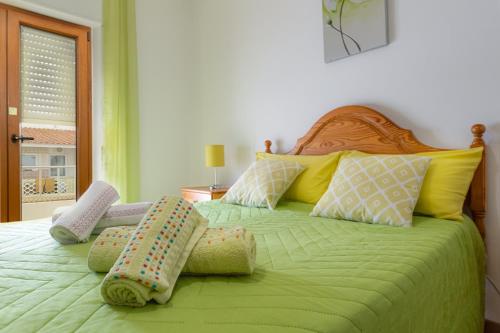a bedroom with a green bed with pillows on it at Best Home 4 Family & Friends - Your Seaside Charm! in Odiáxere