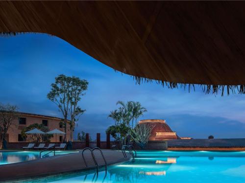 a view of a swimming pool at night at DongFengYun Hotel Mi'Le - MGallery in Mile