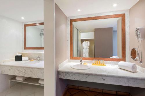 La salle de bains est pourvue de 2 lavabos et d'un grand miroir. dans l'établissement Sandpiper Bay All-Inclusive, Trademark Collection by Wyndham, à Port Sainte-Lucie