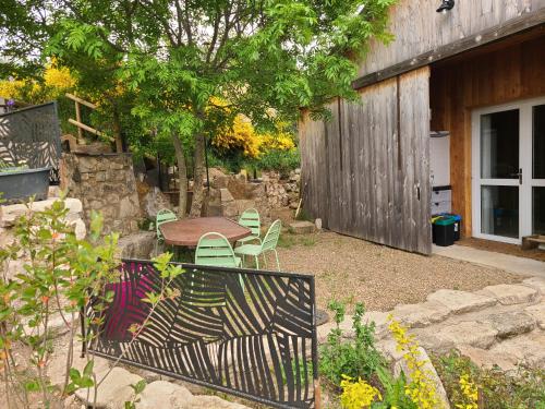 un patio avec une table et des chaises et une clôture dans l'établissement Gites La Boletiere, à Saint-Étienne-du-Valdonnez
