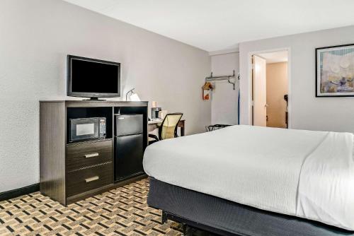 a hotel room with a bed and a flat screen tv at Quality Inn Detroit Downtown in Detroit