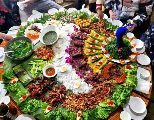 a table with a large amount of food on it at 原乡文苑客栈 in Lijiang