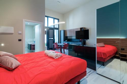 a bedroom with a red bed and a desk at Le Stanze di Gianmarmo - Galleria 41037 in Mirandola