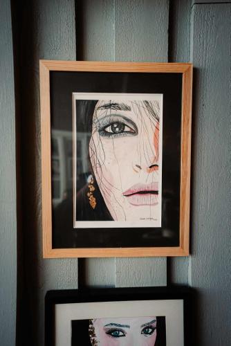 two framed pictures of a woman on a wall at Kræmmervika Havn in Ballstad